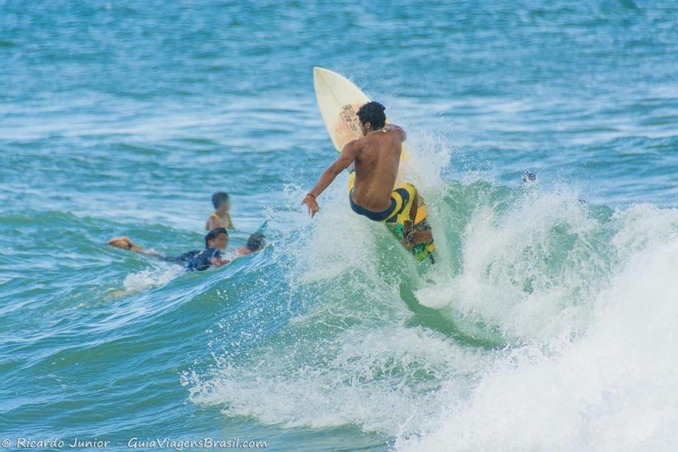 Imagem de rapaz fazendo manobras na onda da Praia da Tiririca.